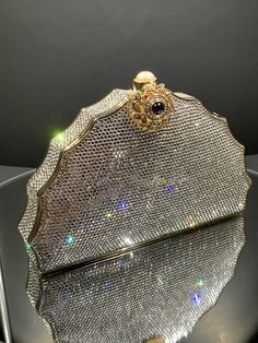 A Ladies Estate Judith Leiber Crystal Minaudiere In A Fan Shape And Completely Covered With Silver Crystals. The Decorative Push Button Clasp Is Set With A Round Mabe Pearl And A Round Cabachon Garnet. It Comes With A 12 Inch Long Chain. There Is Faded Writing On The Inside Of The Minaudiere. Luxury Silver Clutch, High-end Evening Bag, Luxury Handheld Evening Bag, High-end Formal Evening Bag, Luxury Handheld Clutch For Formal Occasions, Luxury Clutch Evening Bag For Dinner, Luxury Rectangular Clutch For Dinner, Luxury Rectangular Evening Bag For Dinner, Art Deco Shoes