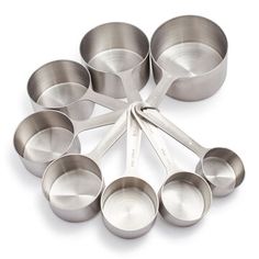 a bunch of measuring spoons sitting on top of each other in front of a white background