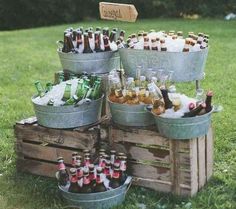 a bunch of beer bottles are in buckets on the grass