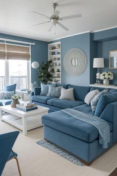 a living room with blue couches and white tables in it's center area