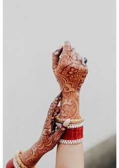 a woman's hand with henna tattoos and bracelets