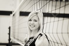 black and white photograph of a woman holding a volleyball net