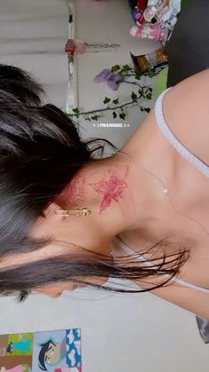 a woman with a tattoo on her neck and chest is looking down at the floor