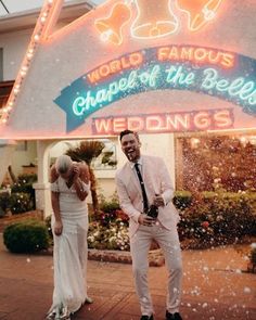 a man and woman standing in front of a sign that says world famous chapel of the bells