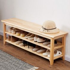 a wooden shoe rack with shoes on it and a hat sitting on the top shelf