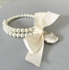 Hand made by Pearly Jane Bridal (me!) just for you when you place an order! I take great care making your order. Please allow two weeks for meticulous construction of your jewelry. If you need your order sooner be sure to let me know! High quality glass pearls Silver locket  Perfect for bridesmaids giftsk one size fits all This bracelet is lovely! Pearls are strung on memory wire and finished with a keepsake locket and an ivory bow. No worries about fitting all your bridesmaids wrists! If more than 1 bracelet is ordered gift boxes are included. Elegant Pearl Charm Bracelet For Bridesmaid, Elegant Bridesmaid Bracelet With Pearl Charm, Silver Pearl Bracelets For Bridesmaid Gift, White Pearl Bracelet For Bridesmaid Gift, Silver Pearl Bracelet For Bridesmaid Gift, Wedding Party Jewelry, Silver Locket, Party Jewelry, Etsy Bridesmaid Gifts