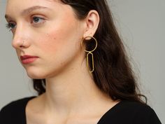 Shapely and distinctive, the Petra Double Drop Earrings reflect the beauty of interconnectedness and feminine form. A perfect partner to a plain white tee and jeans, these geometric delights are handcrafted to last using a layer of gold over Italian brass. Details Everything you need to know. Measures 1.2" in width and has a 2.7" drop. One size. Handcrafted from gold plated Italian Brass in Bali. Each pair is one-of-a-kind. To keep your jewelry looking its best, use a soft, non-abrasive cloth to White Tee And Jeans, Swept Back Hair, Metal Workers, Plain White Tee, Perfect Partner, Stone Collection, Hand Shapes, Traditional Crafts, Plain White