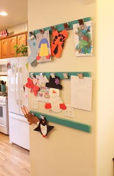 a kitchen with magnets on the refrigerator and pictures hanging on the wall