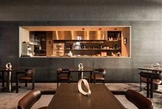 an empty restaurant with wooden tables and brown leather chairs in front of the counter area