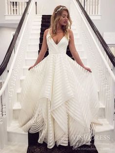 a woman in a white dress is standing on the stairs