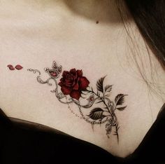 a woman's chest with a rose and chain tattoo on her left side shoulder