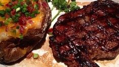 two steaks and potatoes on a white plate