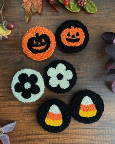 crocheted halloween coasters on a table with leaves and pumpkins in the background