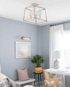 a living room with blue walls and white furniture