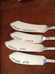 four spoons that say spread happiness, spread love and spread joy on a wooden table