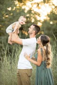 a man and woman holding a baby in their arms