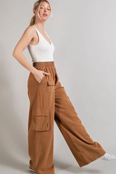 Fit for a day of city explorations, these wide leg mineral washed cargo pants are the epitome of style and functionality. Their distinctive mineral washed finish gives them a worn-in, vintage look that's both trendy and timeless. Equipped with multiple pockets, these pants offer ample storage space while maintaining a comfortable fit, making them a practical choice for outdoor adventures or casual outings. Product Details Material: Self: 100% Cotton. Fit: True to size. Inseam: 31.5” (size Small). Rise: 10.5”Fabric: Stretch cotton. Features: High waisted, wide leg, cargo pockets, elastic waistband, mineral wash. Model: 5’8” / Wearing a size Small. Care: Machine wash cold, gentle cycle. Tumble dry low. Shipping & Returns Free Shipping on U.S. orders +$100. We want you to be 100% satisfied wi Relaxed Fit Linen Cargo Style Bottoms, Relaxed Fit Linen Cargo Bottoms, Casual Linen Parachute Pants With Cargo Pockets, Casual Linen Pants With Multiple Pockets, Casual Washed Brown Bottoms, Casual Brown Washed Bottoms, Brown Washed Bottoms For Fall, Washed Brown Bottoms For Fall, Wide Leg Linen Parachute Pants With Cargo Pockets