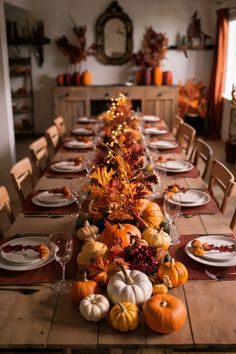 a long table is set with pumpkins and gourds