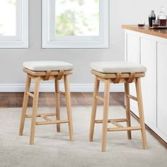 two stools sitting in front of a counter with wine glasses on top of it