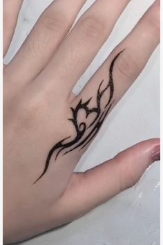 a woman's hand with a tattoo on it and a ring in the middle