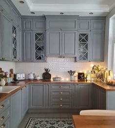 a kitchen filled with lots of gray cabinets