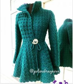 a green coat that is on display in front of a window with the words, croche