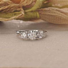 three stone diamond ring sitting on top of a table