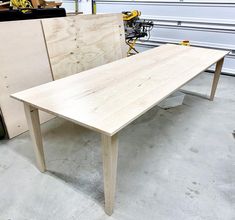 a wooden table sitting in a garage next to some plywood