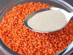 a bowl filled with red lentils and a spoon