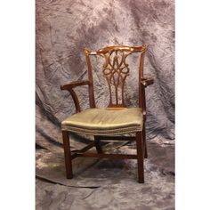 a wooden chair with an upholstered seat and armrests on a gray background