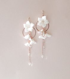 Our long floral earrings boast a stunning round hoop design, perfect for a bridal occasion. Crafted with intricate detail and modern styling, they make a beautiful addition to any ensemble. - Handcrafted with clay flowers and crystal beads - Available in rose gold, yellow gold or bright silver - Earrings measure 4.5 inches x 1-3/8 inch - Nickel free and hypoallergenic Matching pieces: https://www.etsy.com/listing/1584225468/floral-bridal-hair-comb-wedding-hair?click_key=f9cd6e16d327174ff88c05926 Flower Shaped Wedding Earrings With Ear Wire, Elegant Rose Gold Hoop Flower Earrings, Elegant Rose Gold Flower Hoop Earrings, Elegant Hoop Flower Earrings With Flower Charm, Flower Shaped Earrings With Ear Wire For Wedding, Delicate Bridal Earrings For Wedding, Delicate Round Bridal Earrings For Wedding, Elegant Hoop Earrings With Flower Charm, Elegant Flower-shaped Hoop Earrings For Wedding