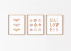 three framed halloween prints hanging on the wall in a white room with pumpkins and bats