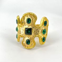 "Stunning Kenneth Lane cuff bracelet features faceted Emerald tone crystals set in satin gold with a light patina finish. The Emerald Green jewels are set in broad raised incrustations inspired by the Yakmur bracelet in the Louvre. Signed KJL for Kenneth Jay Lane. 2\" opening front to back Measures 2-5/8\" across.  Once hinge is pulled back opening is 1&1/2inch 2&1/2\" at tallest Well constructed with good heavy weight in Excellent condition." Gold Jeweled Cuff Bracelet As Gift, Gold Jeweled Cuff Bracelet Perfect As A Gift, Gold Jeweled Cuff Bracelet For Gift, Gold Jeweled Cuff Bracelet For Gifting, Gold Byzantine Jeweled Jewelry, Byzantine Jeweled Gold Jewelry, Byzantine Style Jeweled Gold Jewelry, Gold Cuff Bracelet Bangle With Stones, Gold Stone Bangle Cuff Bracelet