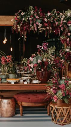 a table topped with lots of potted plants on top of a blue and white striped floor