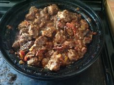 a pan filled with meat sitting on top of a stove