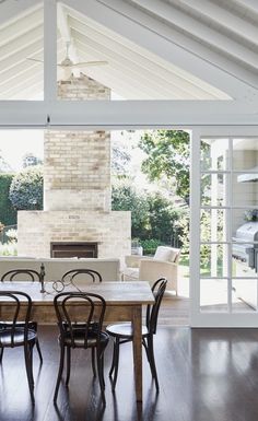 the dining room table is surrounded by chairs and an open fireplace in the back wall