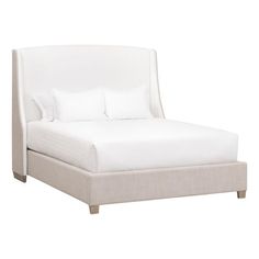 the bed is made up with white sheets and pillows on it's headboard