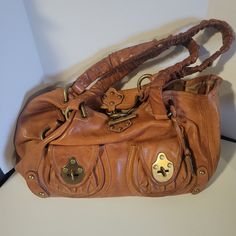 "Vintage Frye Heavy Leather Satchel Handbag With Rivets & Toggle Closure. Bag would benefit from an overall cleaning inside and out. There is a bit of discoloration on the handles which might be improved with cleaning. The lining has a couple of small dark spots, a couple of pink spots, and is a bit soiled from years of use. There are no holes or tears in the lining. The outside leather has a few discolored spots and a couple of whitish spots. Photos are an important part of the description. Mea Vintage Leather Bags With Hardware Details, Vintage Leather Bags With Hardware, Virgo Rising, Frye Bags, Fashion Goals, Leather Satchel Handbags, Satchel Handbag, Satchel Handbags, Fall 2024