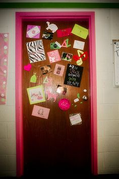 the door is decorated with pink and green paper, cards, and magnets on it