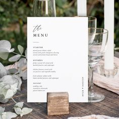 a table setting with wine glasses and menu