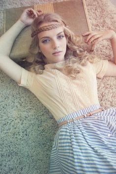 a woman laying on the floor next to a book with her hands behind her head