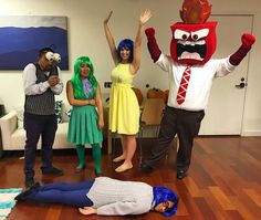 four people in costumes standing and laying on the floor with one person wearing a costume