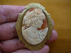 Woman with curls + flowers in hair and on shoulder of gown oval hand carved shell CAMEO brass pin pe Ornate Oval Carved Brooches, Ornate Carved Oval Brooches, Brass Pin, Cameo Jewelry, Carved Shell, Brooch Necklace, Pin Pendant, White Rhinestone, Flowers In Hair