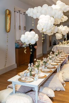 a long table is set up with white balloons