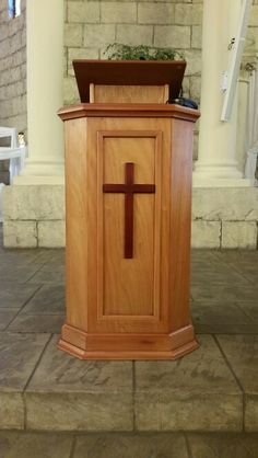 a wooden pulpit with a cross on the front and side panel at the top is shown