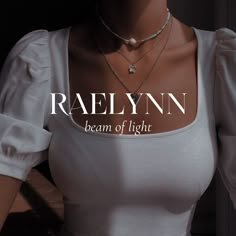 a woman wearing a white shirt and necklace with the words raelynn on it