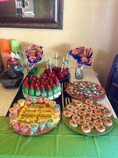 a table topped with lots of desserts and cupcakes on top of plates