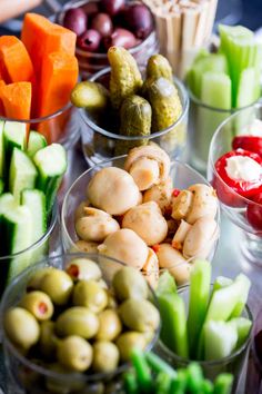 several small bowls filled with different types of vegetables and dips on top of a table