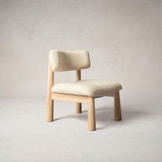 a wooden chair with a white upholstered seat and backrest, against a plain background