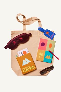 a tote bag with various items on it including sunglasses, passport and eyeglasses